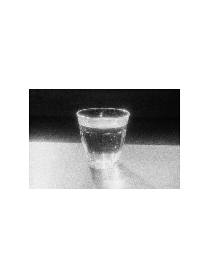 A glass of water on a sunlit table